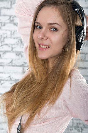 Brown-haired beauty posing with her headphones on and her tits out