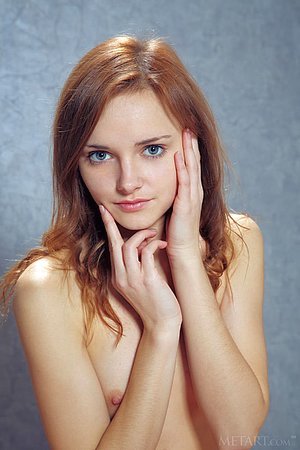 Redheaded chick posing with her legs spread on her red throne